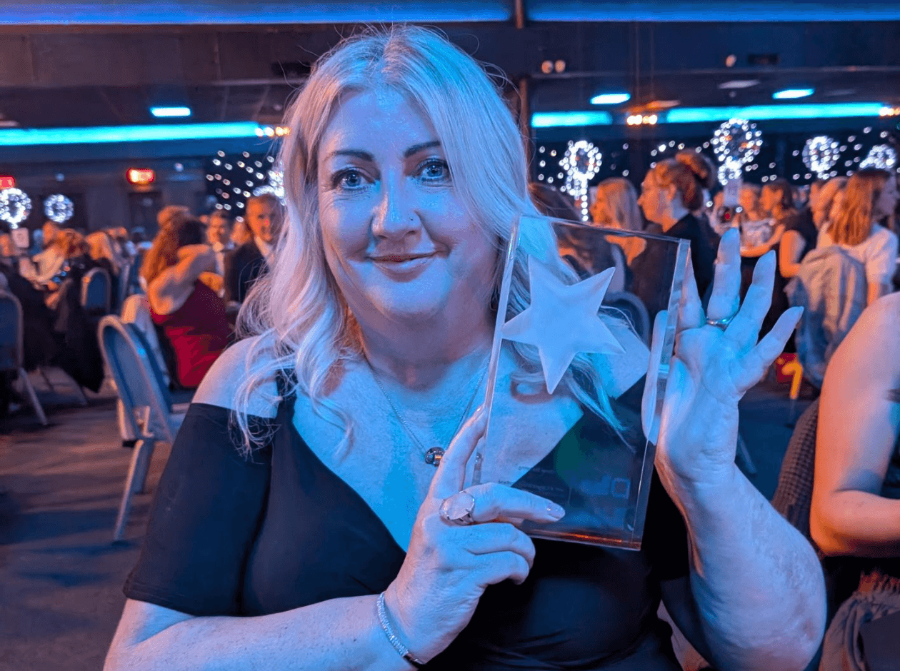 Blonde woman holding award